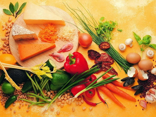 На столе разделочная доска и большое разнообразие различных продуктов питания