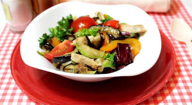В белой глубокой тарелке приготовленный овощной салат с курицей