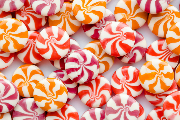 На столе россыпью лежат разноцветные конфеты леденцы без бумажной оболочки