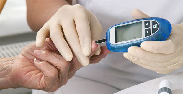 Врач измеряет пациенту уровень глюкозы в крови специальным прибором