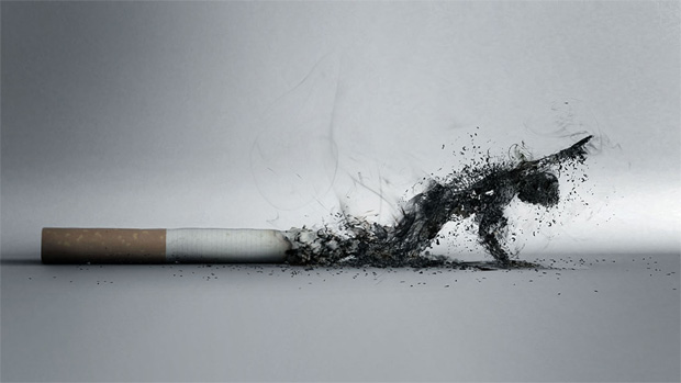 На столе лежит тлеющая сигарета и из пепла образ человека с просьбой о помощи