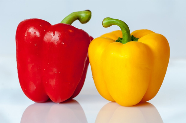 На столе стоят два болгарских перца красного и желтого цветов