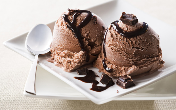 На белом квадратном блюдце два шарика шоколадного мороженого