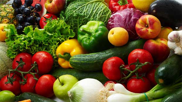 На столе выложены разнообразные овощи: огурцы, томаты, перец, капуста