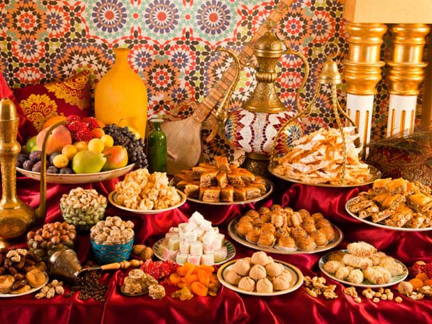 В помещении в восточном стиле на стол выложено большое разнообразие сладостей