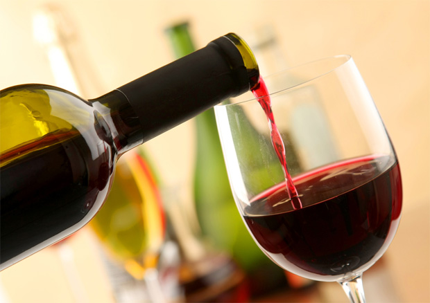 В бокал для красного вина наливают алкогольный напиток из заводской бутылки