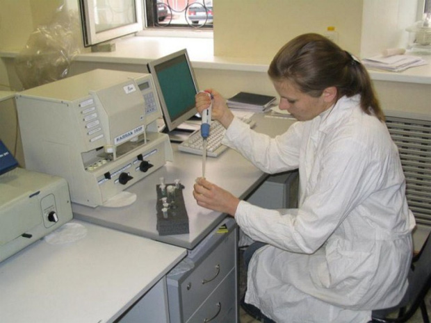 Молодая девушка в лаборатории проводит анализ мочи и крови пациентов